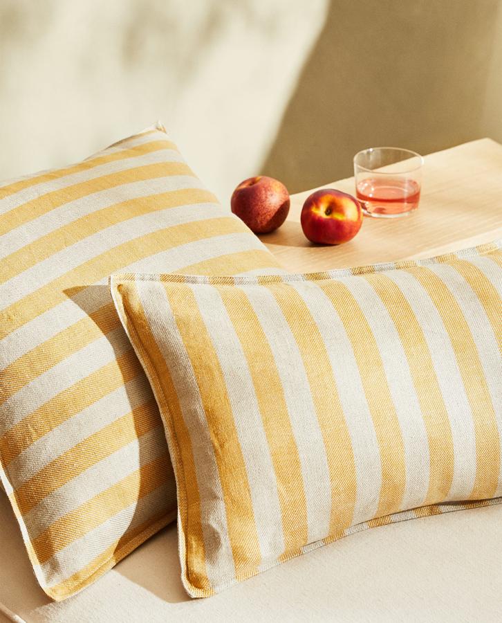 Esta funda de cojín confeccionada en lino con diseño de rayas está disponible en amarillo o en azul. Mide 30x50 centímetros y tiene un precio rebajado de 12,99 euros.