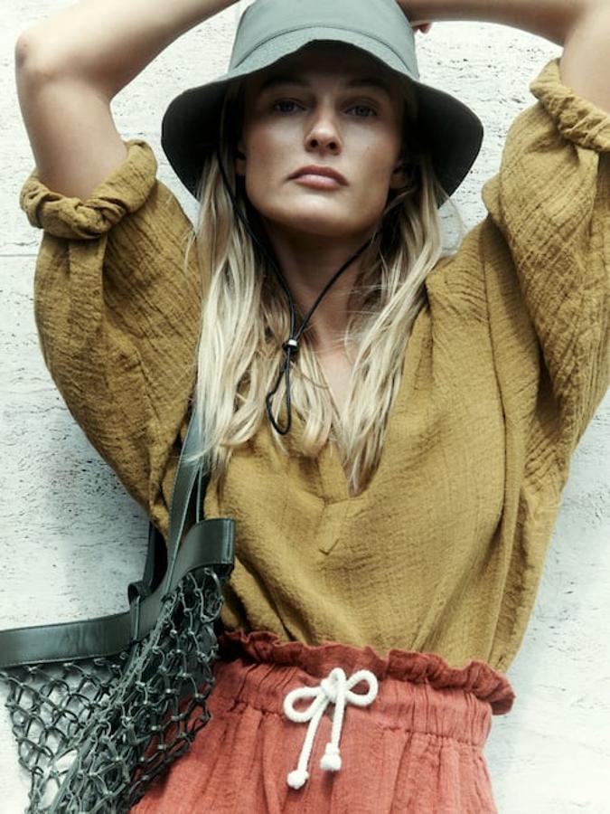 De corte fluido y con cuello de pico, esta preciosa camisa en color aceite que solo podemos comprar en la web de la firma viene con mangas tres cuartos acabadas en puños elásticos y está confeccionada en lino. Tiene un precio de 69,95 euros y está disponible en las tallas S, M y L. 