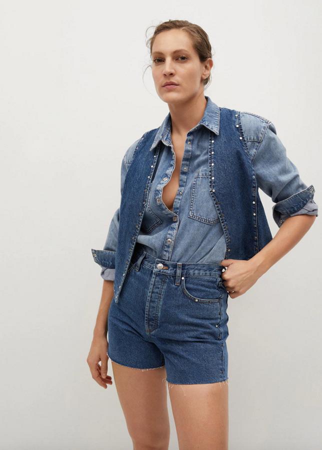 Confeccionado en algodón, con diseño entallado y tachuelas decorativas, estos shorts denim de Mango costaban 25,99 euros y ahora podemos encontrarlos por 17,99 euros.