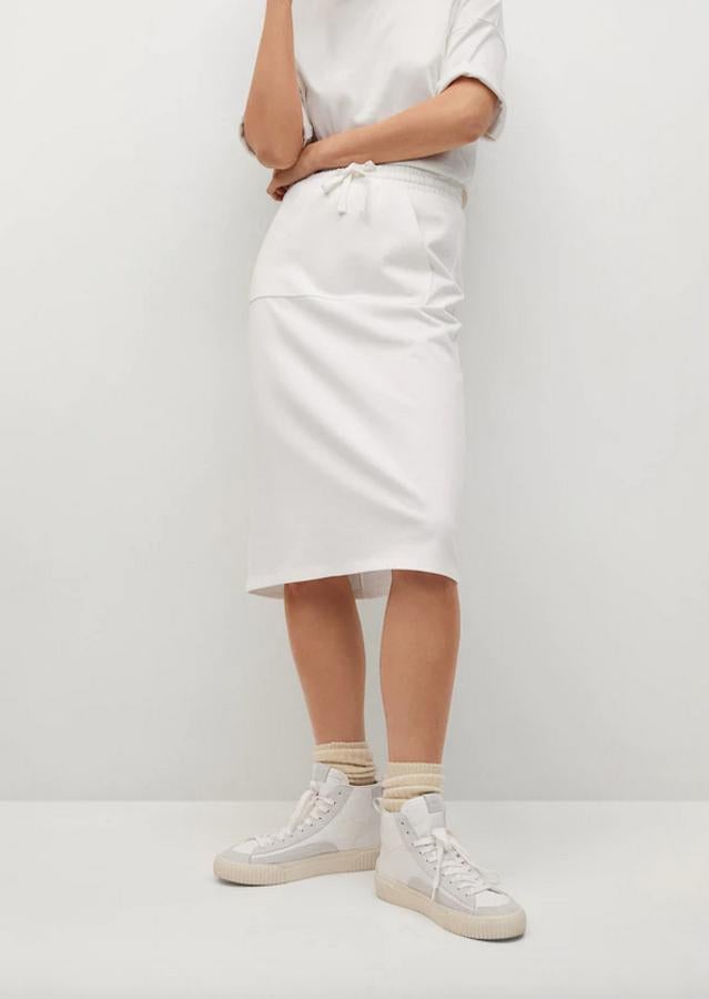 Diseño recto midi para esta falda blanca confeccionada en algodón de tejido elástico que también tiene la cintura elástica y bolsillos de plastrón en los laterales. Cuesta 15,99 euros y podemos encontrarla entre las tallas XS y XL.