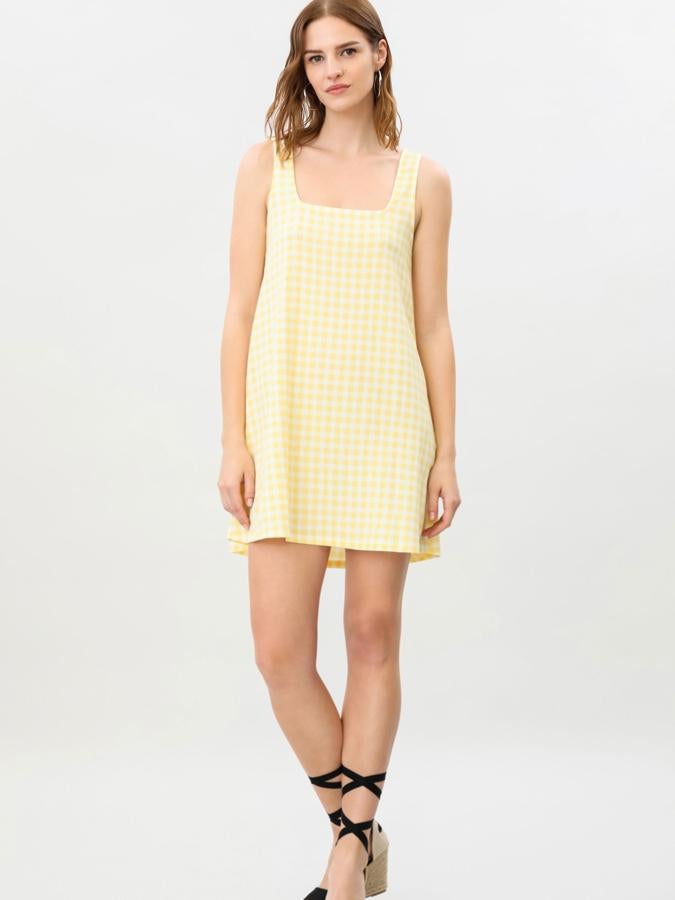 Con estampado de cuadros vichy en amarillo, morado o negro, este vestido de tirantes y escote cuadrado cuenta con un ligero vuelo en la falda y tiene un precio de 9,99 euros.