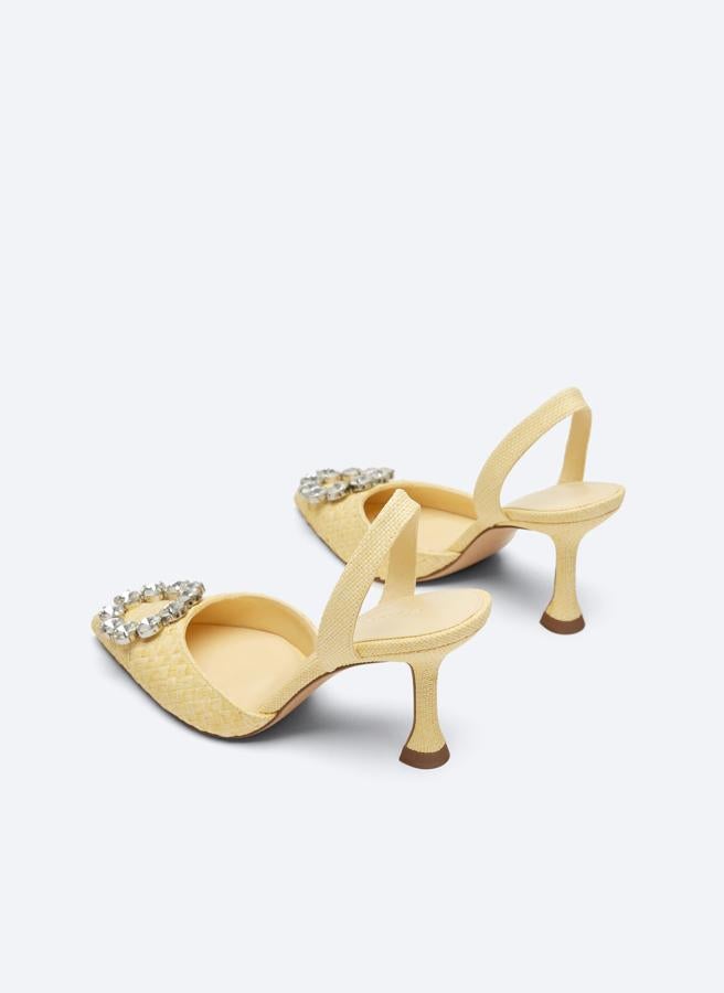 De venta exclusiva en la web de la firma, estos zapatos tipo sandalia destalonada en amarillo pastel con corte trenzado y diseño acabado en punta viene con joya decorativa circular en el empeine y están disponibles entre los números 36 y 40 por 99 euros. 