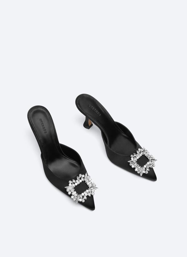 En tejido de raso y diseño acabado en punta, estos zapatos negros con detalle de joya rectangular en el empeine tienen un precio de 99 euros y podemos encontrarlos entre los números 36 y 39. 