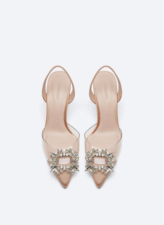 En corte de vinilo y raso en rosa maquillaje, estos zapatos destalonados con tira trasera y joya rectangular en el empeine vienen con tacón de 9 centímetros y podemos encontrarlos entre los números 36 y 41 y cuestan 99 euros.