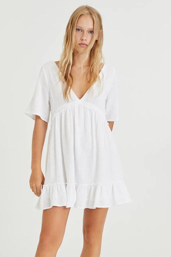 De color blanco y manga corta, este vestido rústico con cuello de pico y detalle de volantes en el bajo tiene un precio de 22,99 euros.