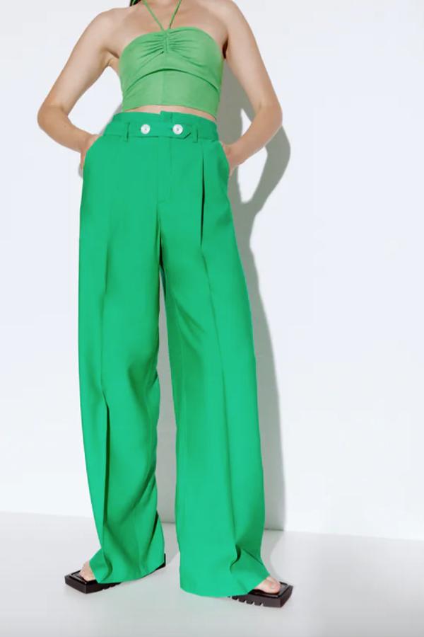 Estos pantalones de color verde son de tiro alto, con bolsillos delanteros, y vienen con detalle de cinturón con botones combinados a contraste. De perneras anchas, tienen un precio de 29,95 euros y están disponibles entre las tallas XS y XL.