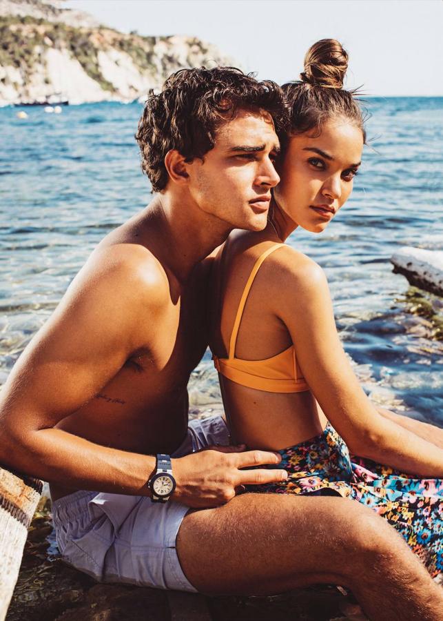 Gara viste top de biquini, de Hermès; y pantalón floral de Stella McCartney. Pepe lleva bañador de Emidio Tucci y reloj Aluminium Chrono tricolore de Bvlgari.