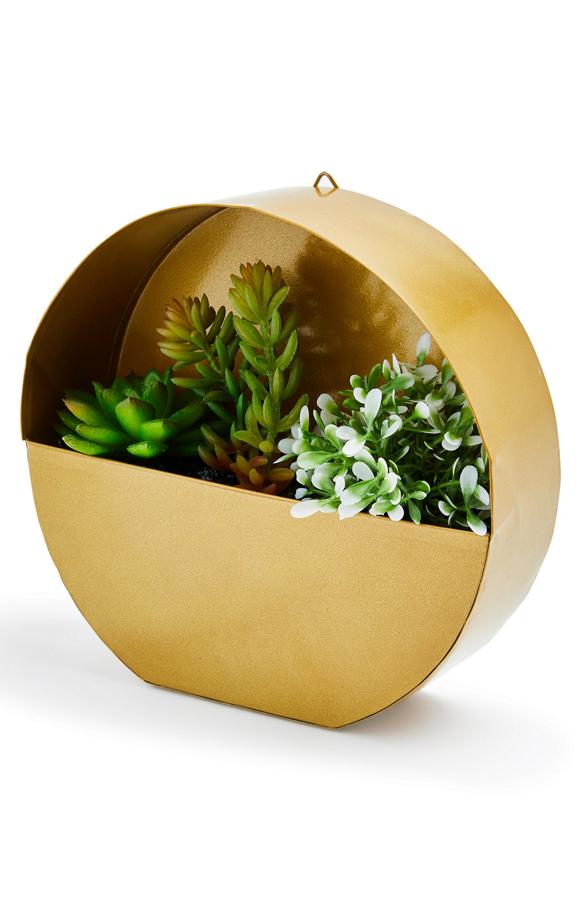 En color dorado y con forma circular, este macetero colgante tiene un precio de 9 euros.