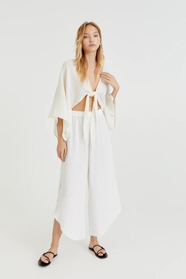 Este pantalón fluido de color blanco cuenta con aberturas en el bajo y cintura elástico. Tiene un precio de 19,99 euros.