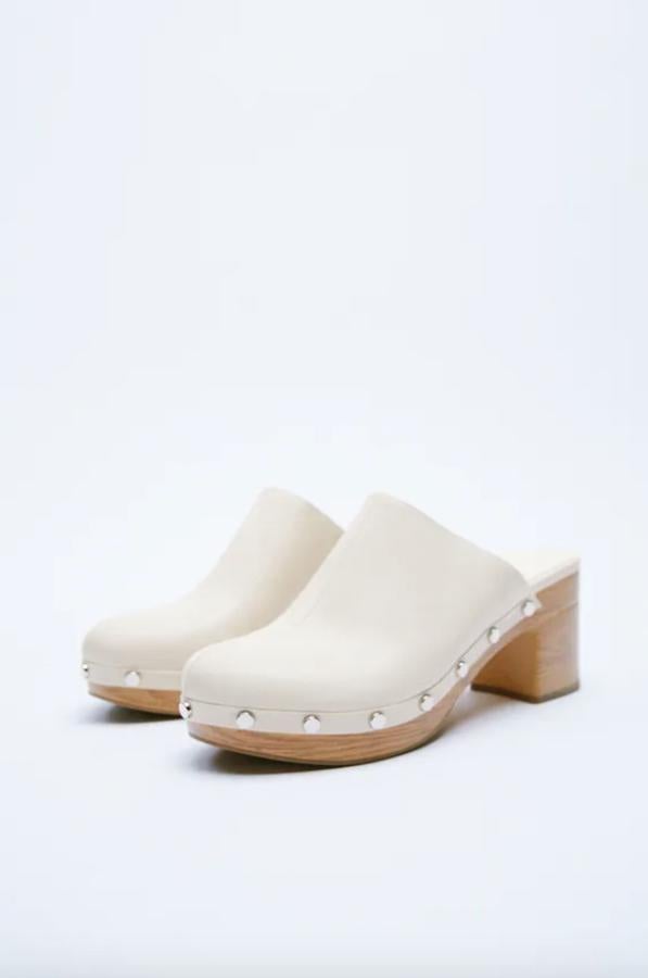 En blanco crudo, con suela en color madera confeccionada en caucho, estos zuecos de Zara con detalle de tachas plateadas tienen un precio de 35,95 euros y están disponibles entre los números 35 y 42. 