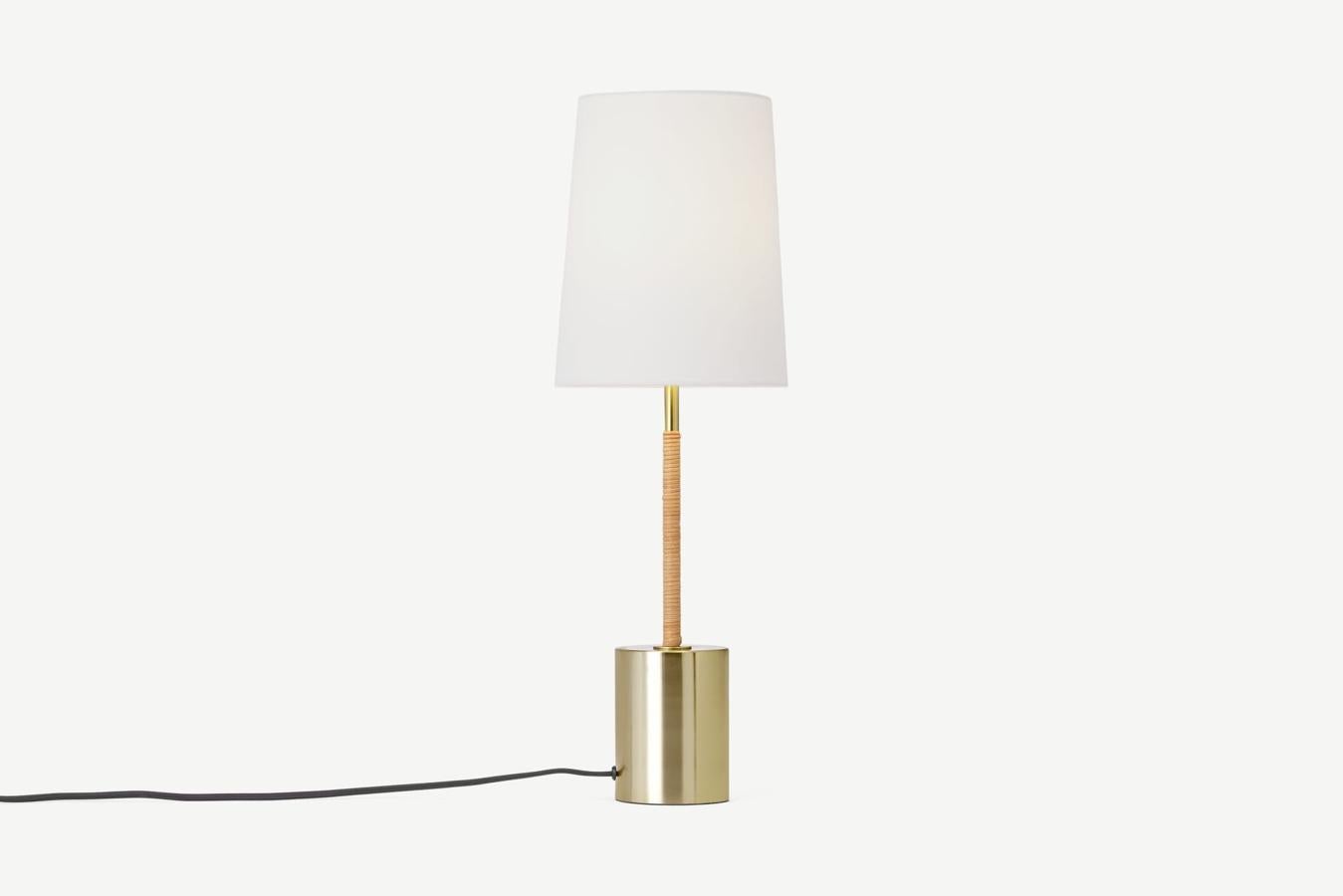 Lámpara de sobremesa en dorado, ratán y pantalla de color blanco (39 euros).