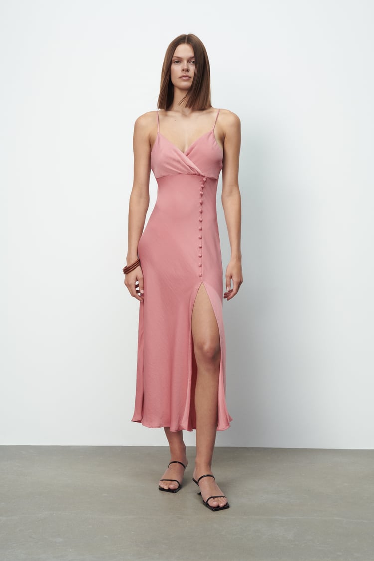 Vestido midi lencero con escote cruzado y abertura lateral con botones, de Zara (25,95 €).