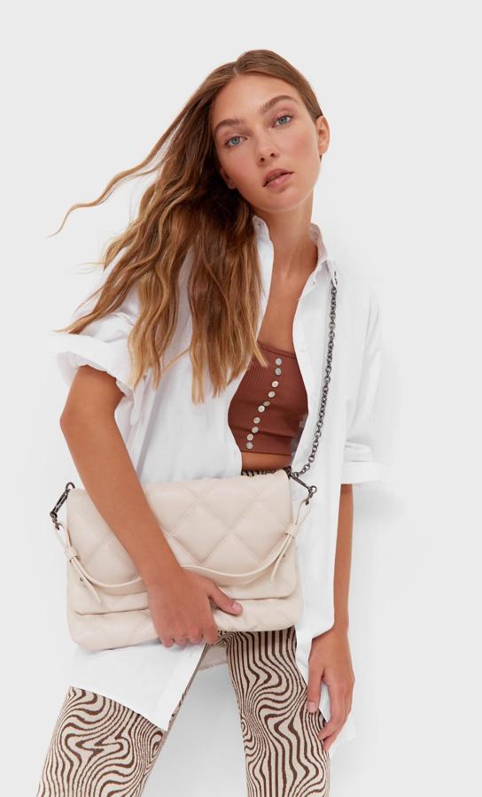 Disponible en color negro y en crudo, esta bandolera acolchada de tamaño medio viene con asa corta a tono y asa larga de cadena mini. Cuesta 19,99 euros. 