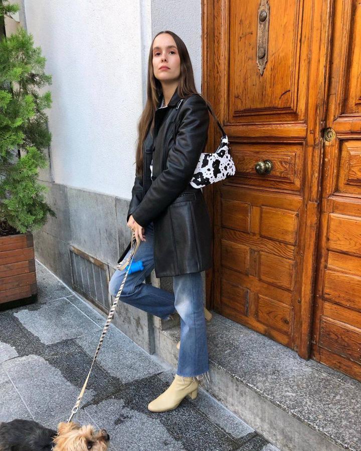 La gabardina de cuero inspiración noventera es un 'must have'. Por sí sola hace todo el trabajo así que no tiene más complicación que conjuntarla con camiseta básica y vaqueros (con bajo deshilachado para un toque más fresco). Completa el look con tus botines de tacón y un bolso baguette.