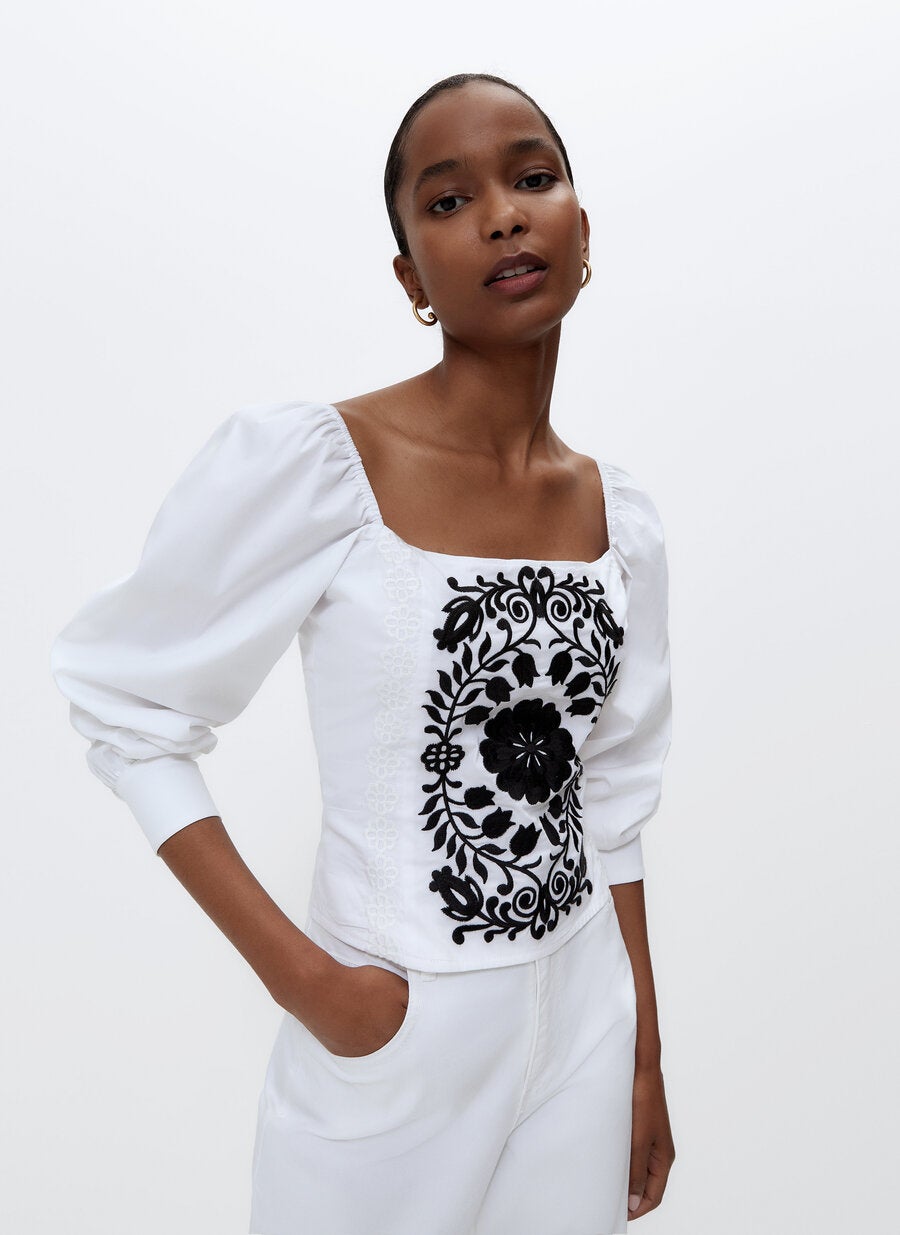 Top de popelín con escote elástico cuadrado y manga francesa abullonada con detalles bordado en el pecho, de las rebajas de Uterqüe (39,95 €). 