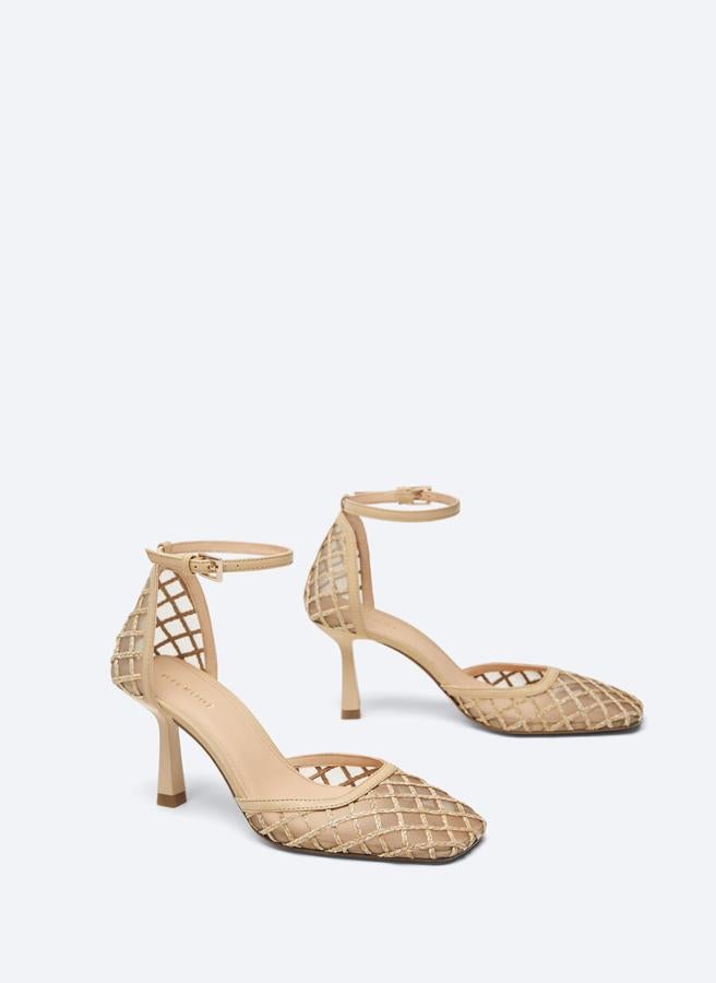 A medio camino entre la sandalia y el zapato, esta pala de Uterqüe en color crudo viene con cierre mediante de pulsera ajustable al tobillo, con corte de rejilla y tejido transparente. Cuesta 99 euros y solo queda en los números 37, 39 y 41.