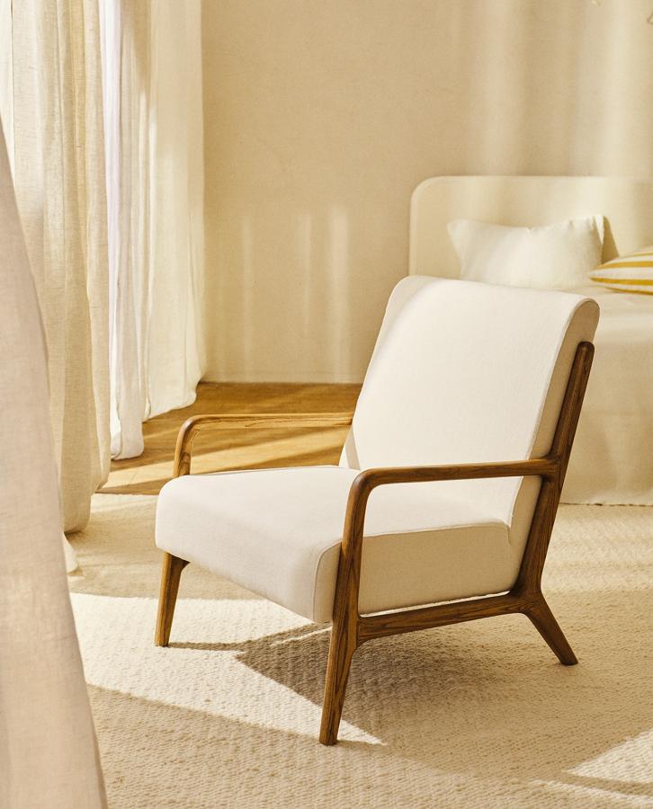 Tapizada con tejido de lino disponible en dos colores, esta butaca con estructura de madera de fresno en color natural tiene un precio de 299 euros.