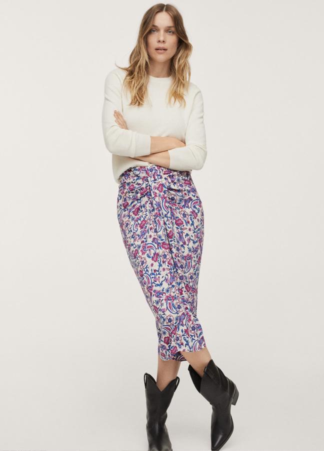 En color crudo con estampado floral en fucsia y azul, esta falda midi con abertura en la parte delantera es de Mango y tiene un precio de 25,99 euros.