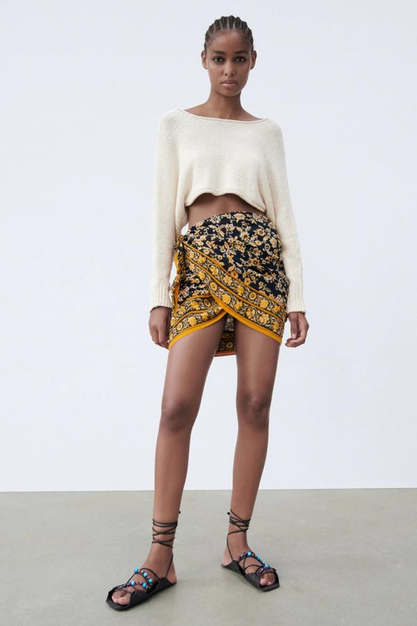 Esta falda pareo de color negro con estampado de amarillo cuenta con bajo asimétrico y cierre con lazada. Es de Zara y tiene un precio de 25,95 euros.