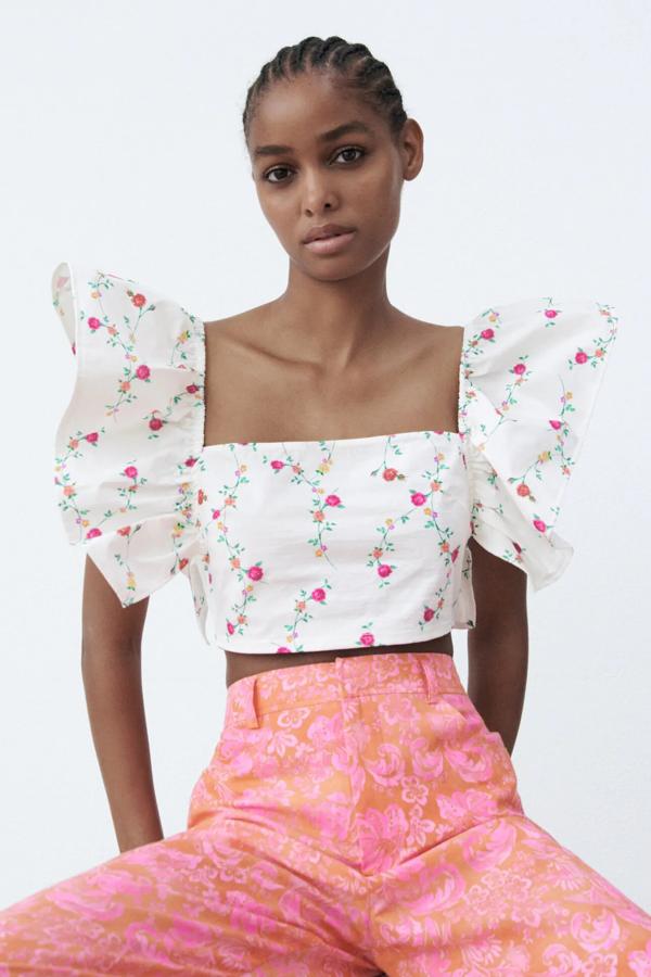 Este top corto blanco con estampado floral cuenta con escote cuadrado y manga sisa acabada en volantes. Tiene un precio de 15,95 euros.