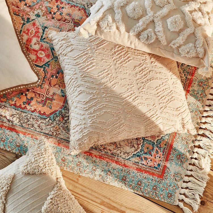 Da un toque de calidez a tu salón o a la habitación con textiles como esta alfombra de estilo vintage (16 euros) o estos cojines (8 euros).
