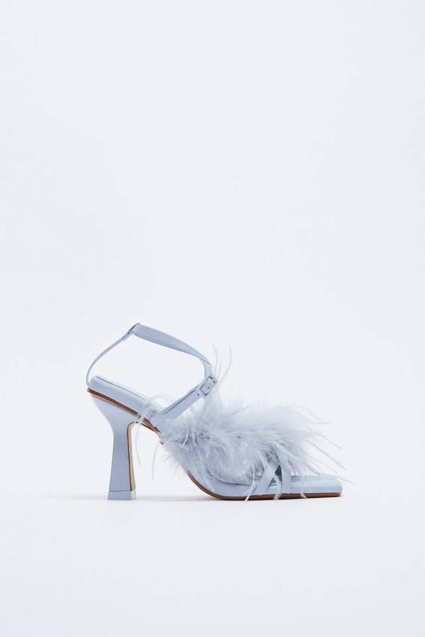 Sandalia de tacón con tiras y detalles de plumas, en gris.