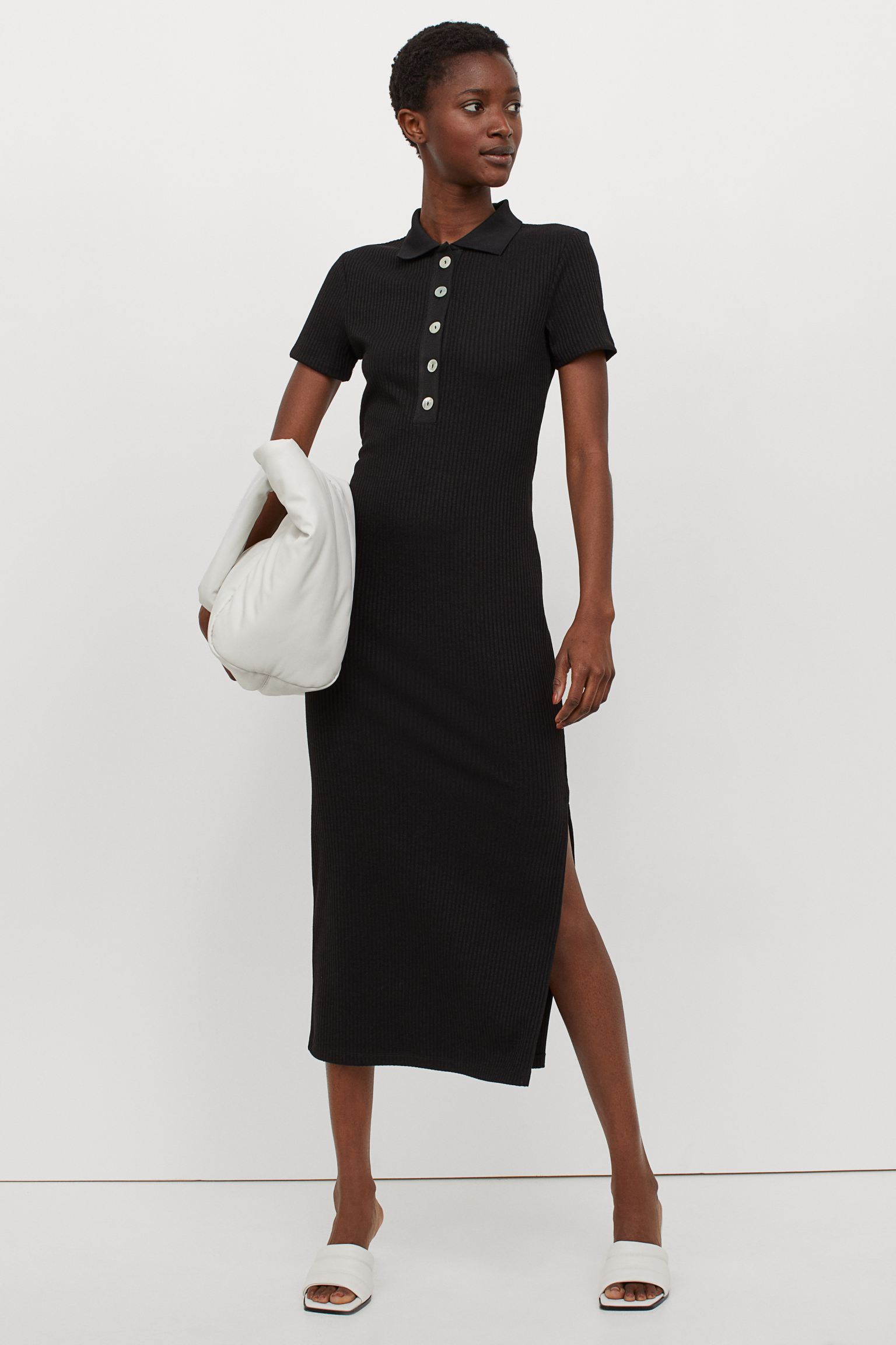 Los vestidos tipo polo han vuelto para quedarse, y este de punto canalé en negro no puede ser más favorecedor. Cuesta 23.99 euros en las rebajas de H&M.