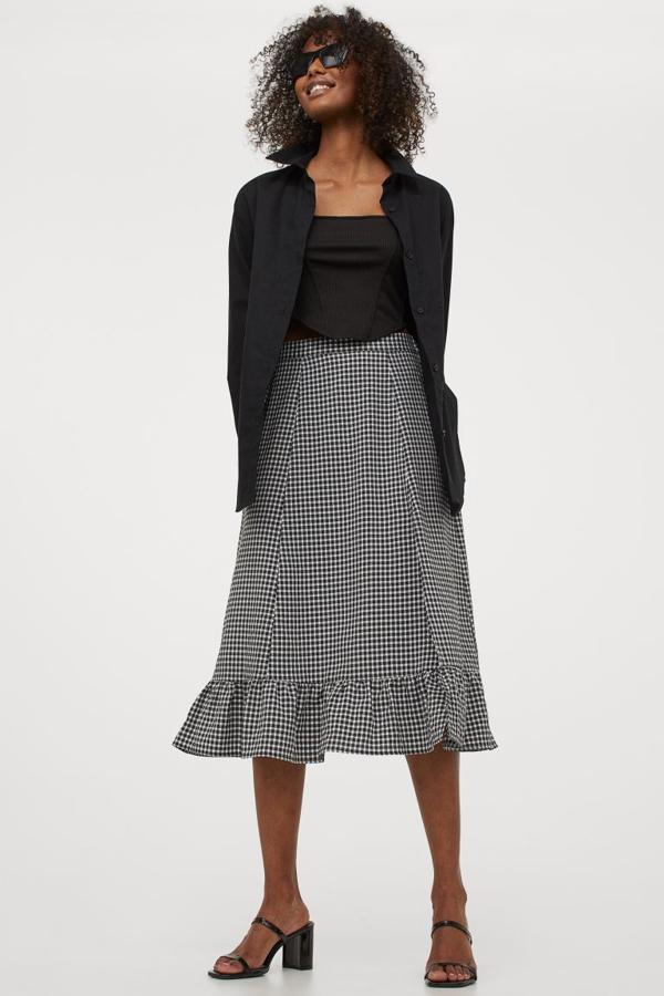 Estampado de cuadros negros y blancos para esta falda de H&M de diseño midi y confeccionada en tejido de viscosa. De talle alto con elástico revestido en la espalda, volante ancho en el bajo y abertura en un lateral, cuesta 19,99 euros y está disponible entre las tallas XS y L. 
