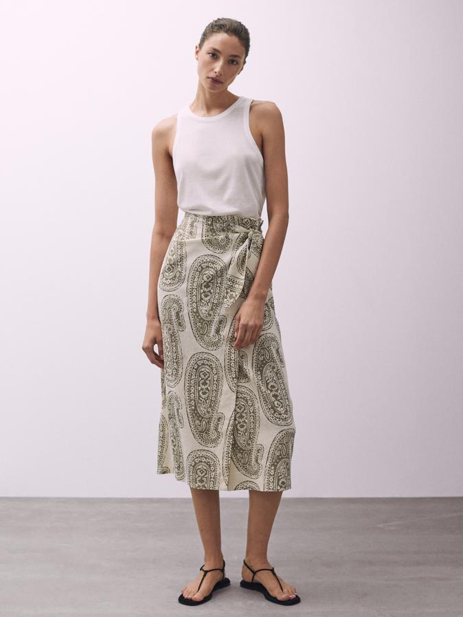 En color crudo, con estampado paisley en caqui, esta falda midi de Massimo Dutti con nudo y abertura lateral tiene un precio de 59,95 euros y está disponible entre las tallas 34 y 42. 