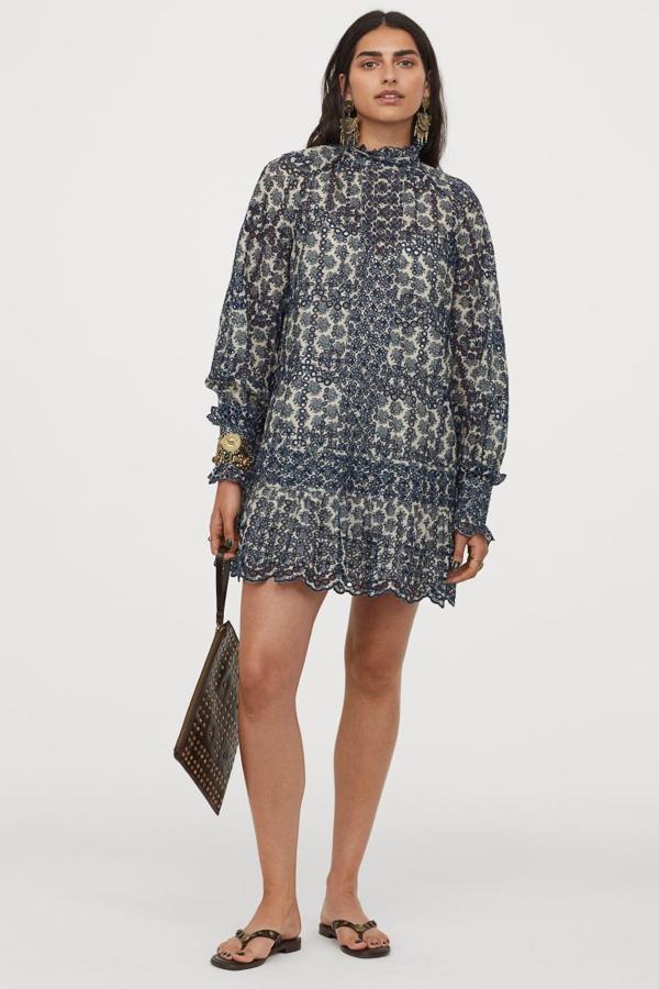 Diseño corto para este vestido de algodón con bordado inglés que viene con cuello elevado con ribete de volantes decorativo, mangas largas fruncidas con elástico fino y falda festoneada con ligero vuelo y costura en el bajo. Tiene un precio de 79,99 euros. 