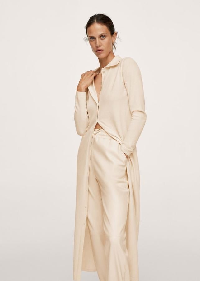 Este cárdigan largo de Mango en color vainilla es de diseño recto y viene con cuello clásico, terminaciones en canalé y cierre de botones con efecto nácar en el frontal. Es de punto fino, tiene las mangas largas y podemos encontrarlo entre las tallas XXS y XXL por 19,99 euros. 