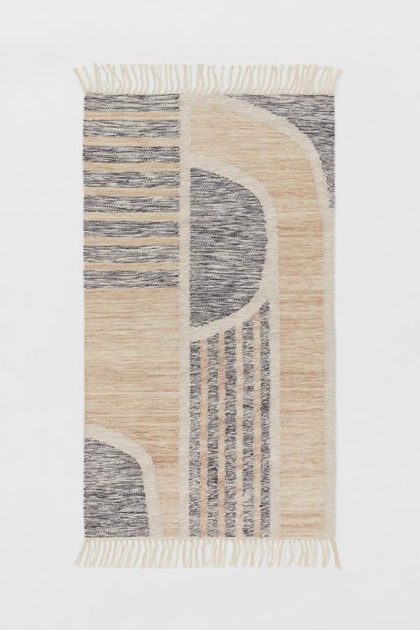 En mezcla de lana y algodón con flecos en los extremos, esta alfombra estampada mide 80x140 centímetros y tiene un precio de 69,99 euros. Está disponible en dos colores.