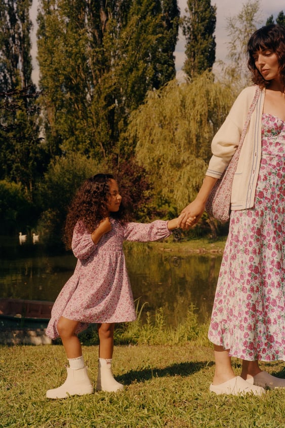 Dos vestidos y un estampado de flores: el de niña, en nido de abeja, cuesta 22.95 euros; el de 'mayor', de largo midi, 39.95 euros.