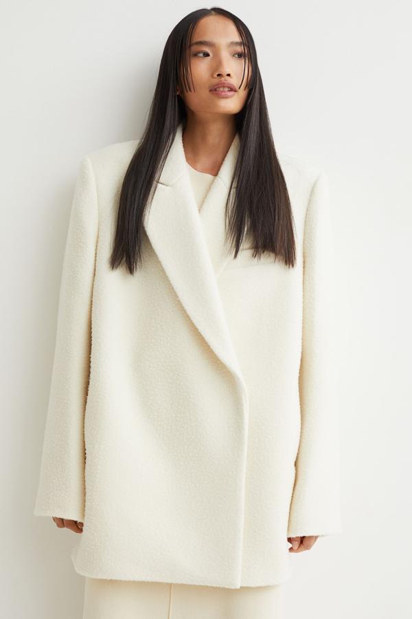 De venta exclusiva en la web de H&M, este abrigo corto en mezcla de lana y color crema es de corte relajado con cuello, solapas de pico, cierre de botones de presión ocultos y bolsillos en las costuras laterales. Confeccionado en mezcla de lana suave, tiene un precio de 149 euros y solo queda en las tallas S, M y L. 