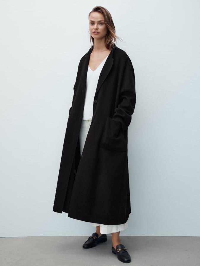 Diseño oversize para este abrigo negro confeccionado a mano en lanza que tiene cuello con solapa de muesca y cierre mediante dos botones a tono. Con dos bolsillos de plastrón en el frontal, es de Massimo Dutti, cuesta 199 euros y está disponible entre las tallas XS y L. 