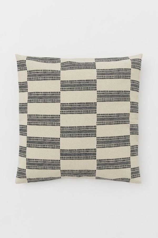 Con estampado, en color beis y negro y fabricada en algodón. Esta funda de cojín es perfecta para darle un toque atemporal a cualquier sofá. Tiene un precio de 2,99 euros en H&M Home.