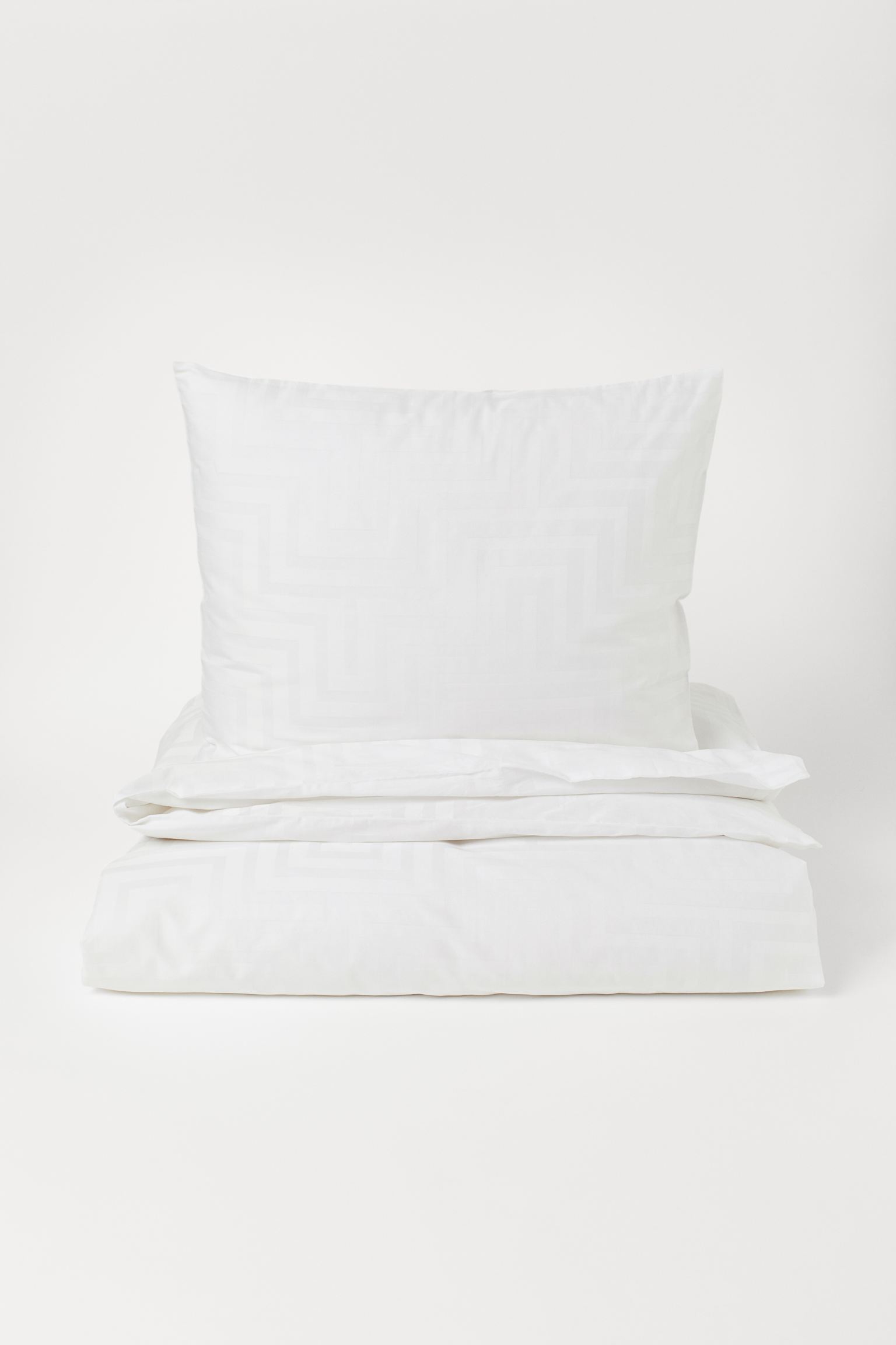 Elegante y muy sofisticado, este juego de funda nórdica en satén blanco con estampado a tono está rebajado de 49.99 a 19.99 euros en H&M Home.