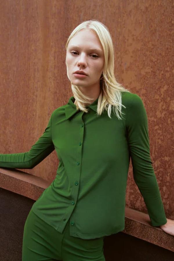 No es una camisa, es una camiseta, pero como viene con cierre frontal de botones a tono y cuello solapa nos vale perfectamente para sumarnos a esta tendencia. De mangas largas, es de Zara, cuesta 17,95 euros y está disponible en las tallas S, M y L. 