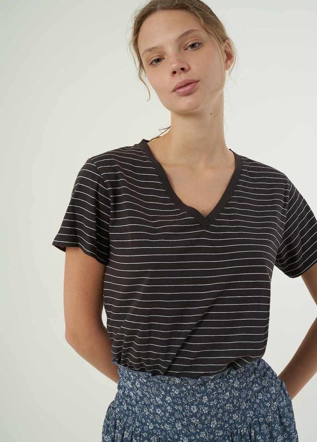 Una camiseta sencilla es un básico imprescindible y esta de rayas con el cuello en forma de pico nos encanta. Tiene un precio de 25,90 €.