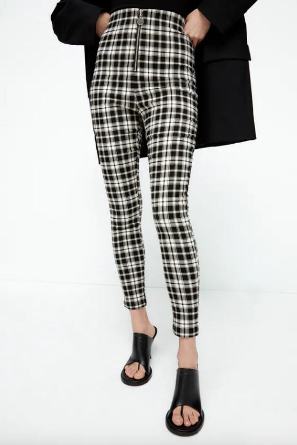 Con estampado de cuadros en blanco y negro, estos leggings de tiro alto con cintura elástica de Zara vienen con cierre frontal con cremallera metálica y cuestan 19,95 euros y están disponibles entre las tallas XS y XXL. 