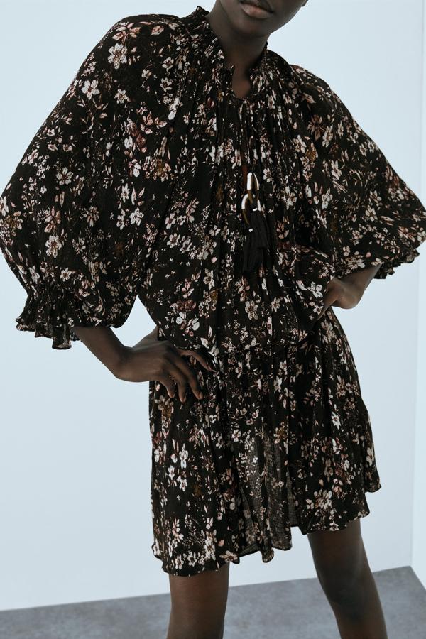 Más mini vestidos que no pueden faltar en tu armario de otoño. Sus señas de identidad son un estampado de flores más invernal y un bonito plisado que le aporta un ligero toque  boho . Vestido negro con estampado de flores de Zara (39,99 euros)