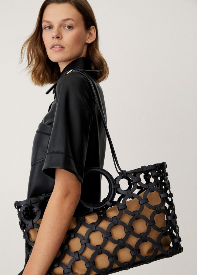 Los bolsos estilo shopping bag son perfectos para el día a día. Grandes y fáciles de combinar, pero siempre con un toque estiloso. Este diseño calado es el más original del momento. Bolso en marrón y negro de Mango (49,99 euros) 
