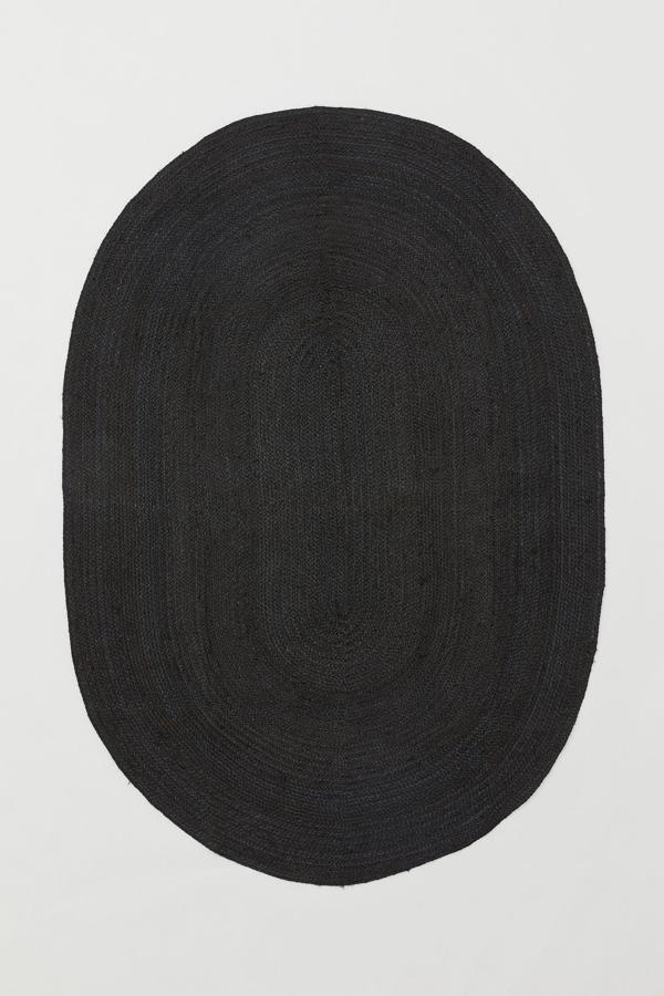 Disponible en negro o en beige, esta alfombra ovalada de yute mide 170x240 centímetros y tiene un precio de 149 euros.
