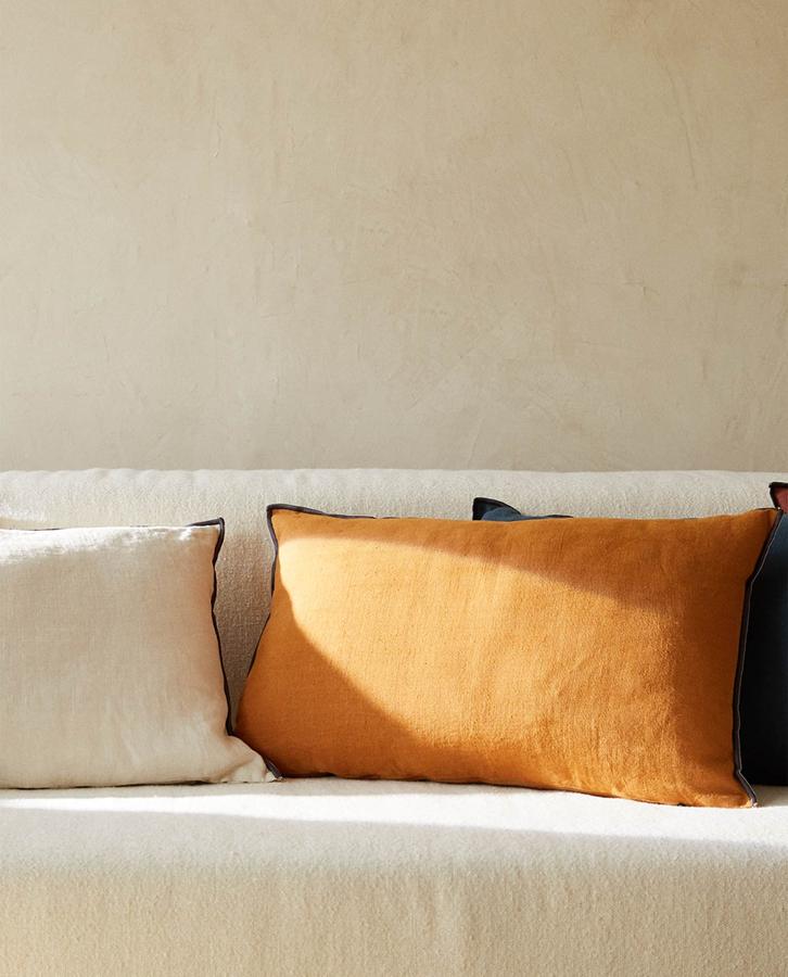 Disponible en varios colores, este cojín con relleno confeccionado en lino y overlock en el contorno tiene una medida de 40x60 centímetros y un precio de 29,99 euros.