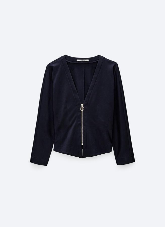 No puede faltar en la selección una camisa negra y la podemos encontrar en Uterqüe confeccionada en tejido calado. Con escote de pico y cierre de cremallera frontal, es de diseño ceñido y podemos encontrarla en las tallas S, M y L por 79 euros