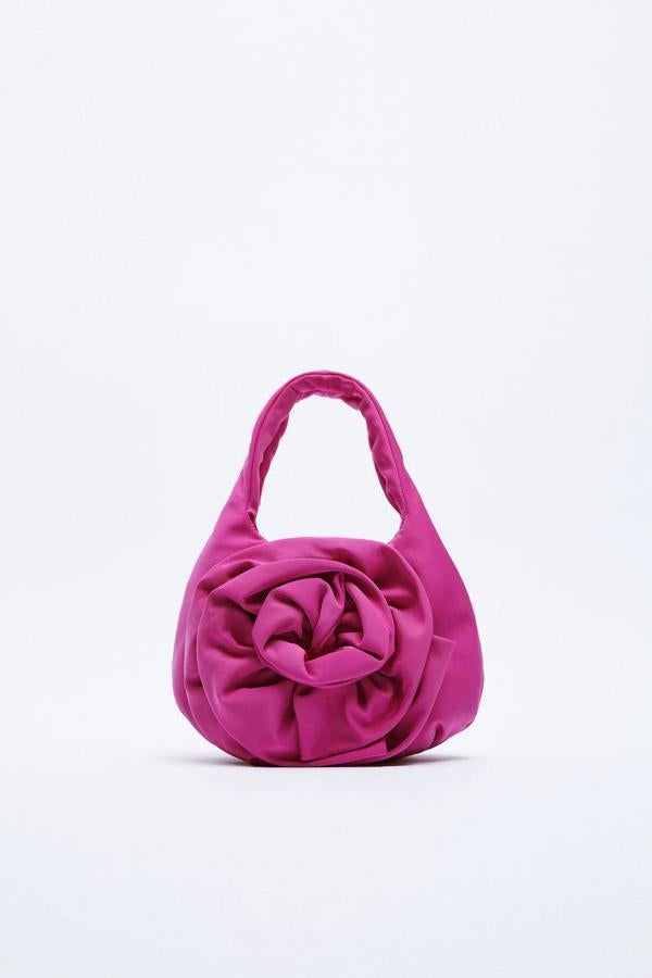 Bolso formato mini shopper de tejido con detalle de flor, en fucsia. 29,95 euros.