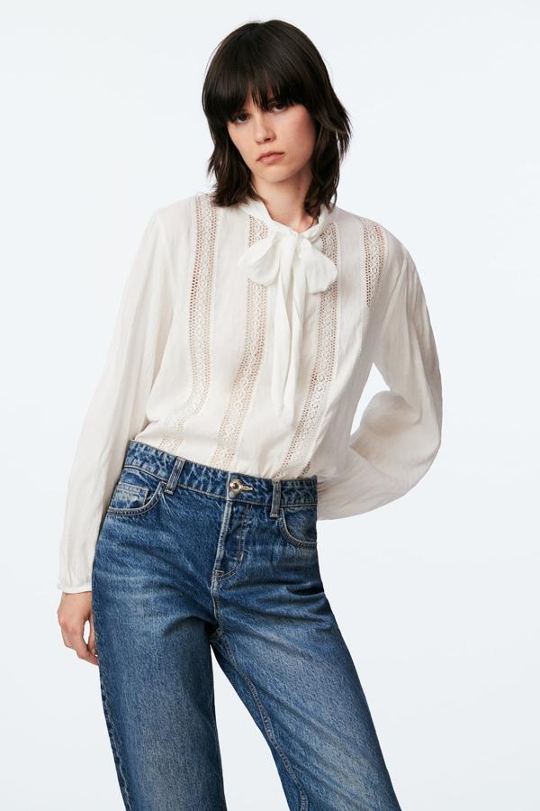 Con la llegada del otoño siempre vuelven las blusas blancas más románticas. Y en Zara siempre se pueden encontrar los diseños más bonitos. Blusa con lazada y detalles de encaje de Zara (29,99 euros) 