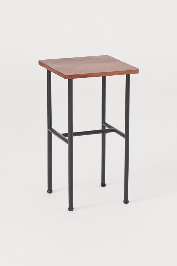 Con las patas en metal pintado de color negro (también disponible en blanco); esta mesa auxiliar pequeña con forma cuadrada en MDF tiene una altura de 53,5 centímetros y un alto y un ancho de 30. Su precio es de 39,99 euros.