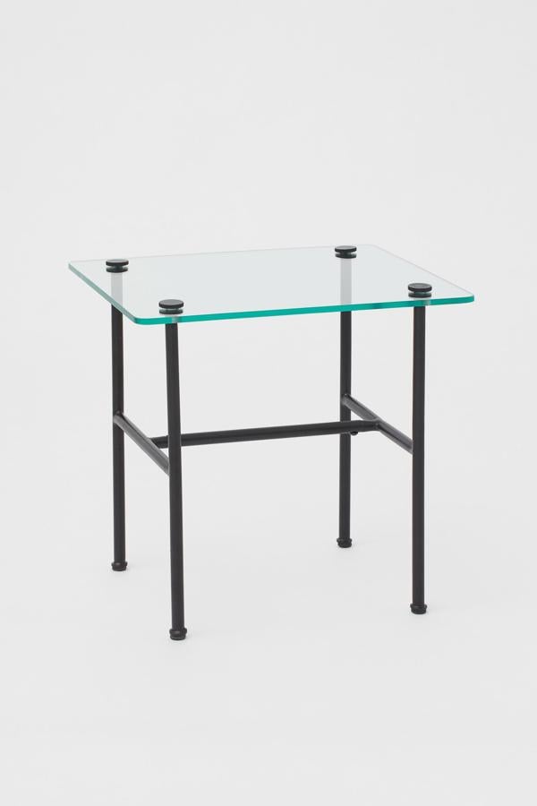 De vidrio con patas en metal de color negro, esta mesa auxiliar tiene unas medidas de 40x40x45 centímetros y un precio de 69,99 euros.