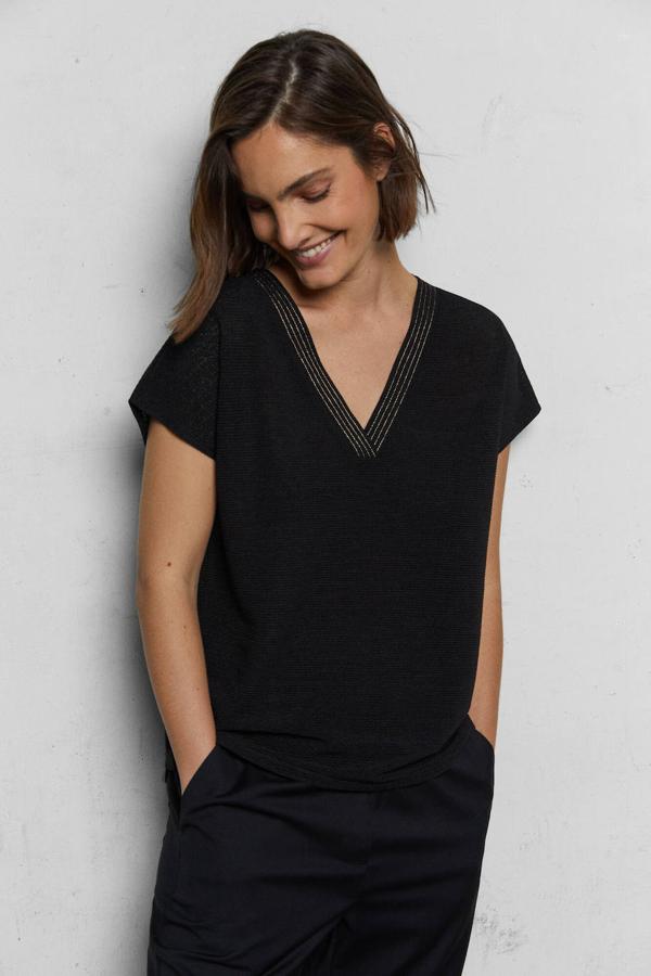 Un top con textura siempre es una apuesta segura y este de color negro tiene un precioso detalle de cadeneta en hilo de lúrex en el escote. Puede ser tuyo por 25,99 €.